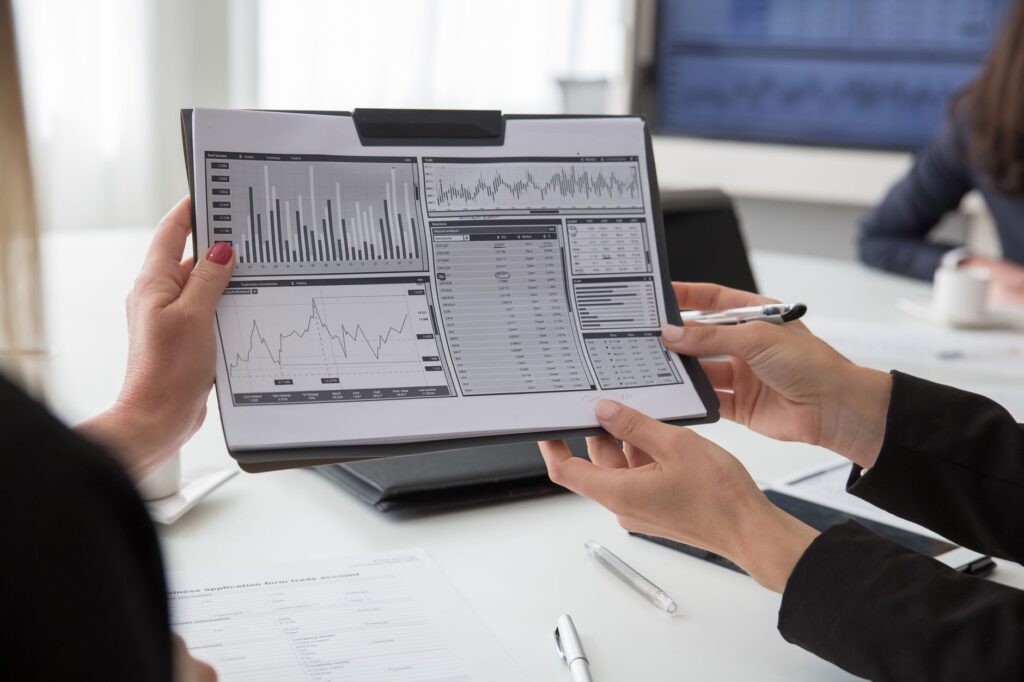 Professionals reviewing data charts on paper during a business meeting.